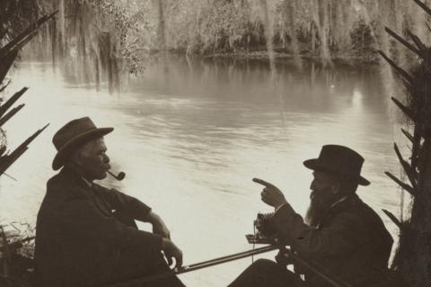 Two men sitting under Spanish moss at Blue Spring in 1905.