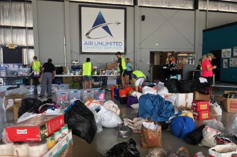 The Air Unlimited team sorts through donations inside their hangar at the Sanford airport before delivering supplies to the Bahamas.