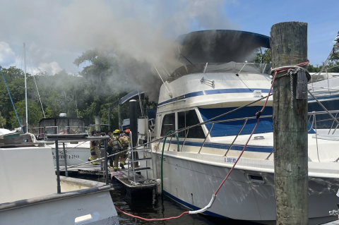 Firefighters work to put out flames on a 36-foot Chris Craft this Thursday in Boat Tree Marina.