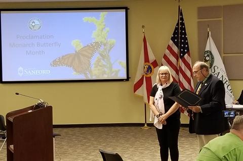 Sanford Urban Forester Elizabeth Harkey stands with Mayor Art Woodruff while he reads the proclamation at Monday’s commission meeting. 