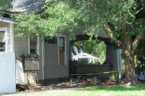Police tape shows where the car hit the home.