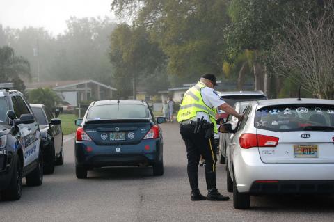 Sanford Police Officer Mike Bernosky hands out tickets near Airport Boulevard and Park Avenue on Tuesday morning. 