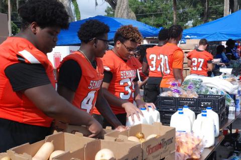 Football players from Seminole High School help with the food distribution on Friday at Allen Chapel AME Church.