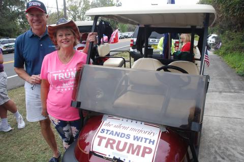 Sharon Hanson with her husband, Dale, and their golf cart waiting for Trump’s arrival.