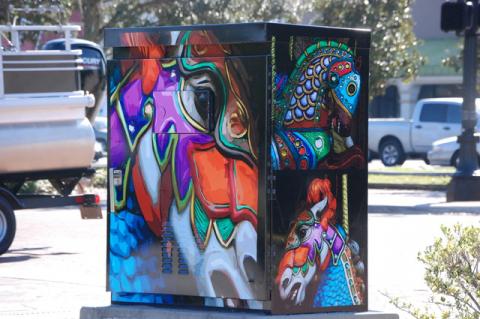 The Utility Box Wrap Project is well underway in Downtown Sanford as artists’ works go up to add color to the drab boxes. According to the City of Sanford website, the project will “enhance the urban environment and further the tourism and economic potential of the City.” The city’s Public Art Commission put out a call to artists to supply the renderings seen popping up on 18 utility boxes along 1st Street from French Avenue on the west to Sanford Avenue and down Sanford Avenue south to 5th Street. 