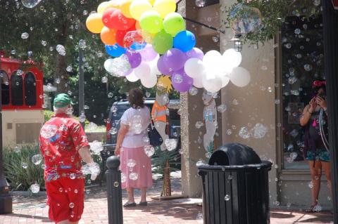 A blizzard of bubbles (above, below) swept over the corner of Sanford Avenue and 5th Street at Saturday’s Christmas in July event organized by the Sanford Mercantile Association in collaboration with Sanford Main Street and Historic Downtown Sanford. Businesses taking part in the event reported brisk business during the day. 