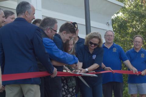 Zechariah Cartledge, third from left, cuts the ribbon at the grand opening ceremony of the Running 4 Heroes Tribute Hall. He was surrounded by his family, the Winter Springs Commission, and Winter Springs Mayor Kevin McCann. 