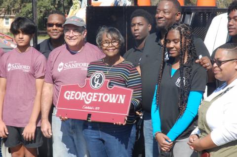 Members of the Young Men of Excellence, the Young Women of Excellence and the Mayor’s Youth Council join, from left, Robert Guy of Seminole County Public Schools, Sanford Mayor Art Woodruff, Julia Wright Brunson (holding sign) of the Georgetown Steering Committee, Sanford Commissioner Kerry Wiggins Sr. (tallest) and Commissioner Sheena Britton, lower right.
