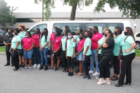 Members and mentors from the Glorious Hands organization pose before the group’s new 15-passenger van donated by Dan Gilardi and the Father’s Table Foundation in Sanford.