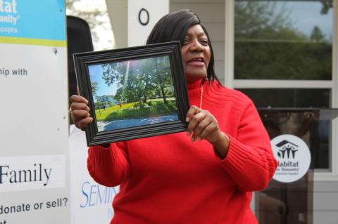Sandra Smith (above) holds a photo taken of her building lot with a beam of light shining down.