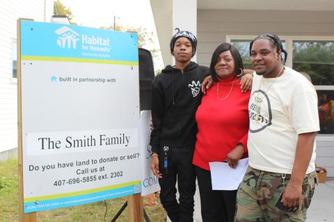 Homeowner Sandra Smith (center) celebrates at the ribbon cutting for her new Habitat for Humainty home with her grandson Jonathan Smith (left) and son Byron Smith (right) this past weekend.
