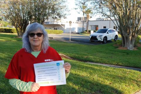 Louella Ellis, an ICU nurse from Central Florida Regional Hospital, holds a pamphlet she shared with co-workers Thursday morning to protest what the nurse’s union has called a lack of proper equipment to care for patients during the coronavirus pandemic.