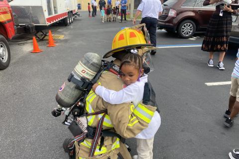 A firefighter hugs one of the children at Midway Elementary during National Fire Prevention Week.