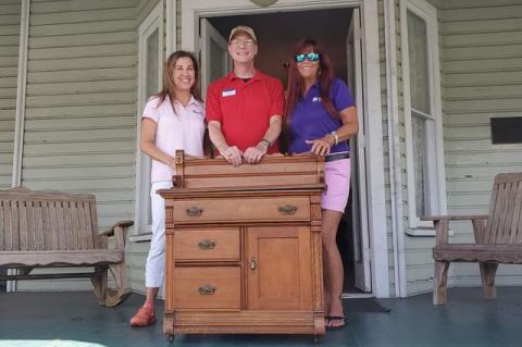 Members of the historical society show off the piece of furniture that belinged to the Bradlee-McIntyre House in Longwood. 