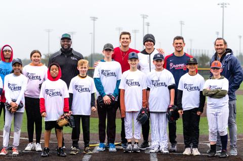 Professional Major League Baseball players pose with some of the participants of the Grow the Game event.