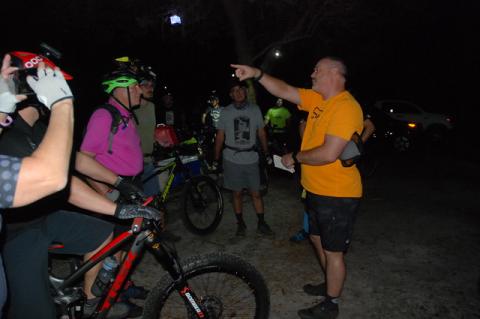 Trail boss Jason Lampitt (right) instructs riders before they take off for the night time ride along the Markham Woods Trailhead on Wednesday.