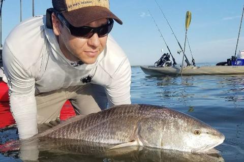 Justin Ritchey with a red drum caught while kayak fishing.