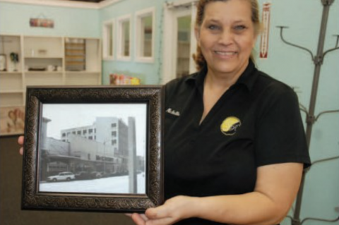 Michelle Simoneaux holds up an old photo of McCrory's store in the same location where a new country store will open. 