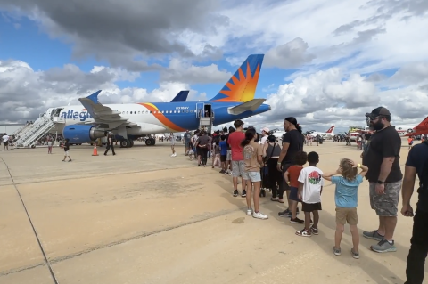 Students and their families line up to tour an Allegiant Air commercial aircraft during Aerospace and Aviation Day, which was held Saturday at the Orlando Sanford International Airport.