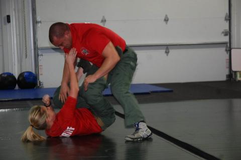 In a training exercise, Deputy Katelyn Charnas, on floor, fights off Sgt. John Martin.