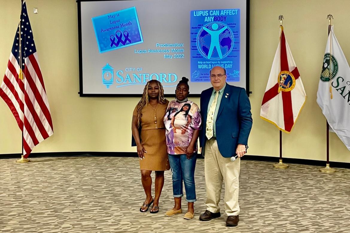 Family members of Ondraneika Williams (left) accept a proclamation from Mayor Art Woodruff (right) naming May Lupus Awareness Month in the City of Sanford. May 10 was also World Lupus Day in honor of Ondraneika Williams.